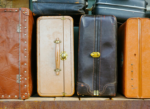 A collection of leather and fabric suitcases in a row.