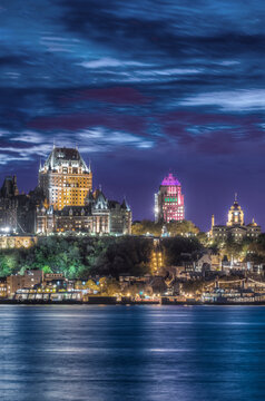 The city of Quebec at dawn, the historic buildings of the parliament and walled old town, and modern skyscrapers.
