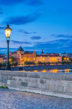 The Charles Bridge at dawn, a cobbled roadway and parapet, and view to the castle.