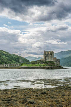 Eilean Donan Castle, a 13th century fortified tower house on a loch in the mountains.