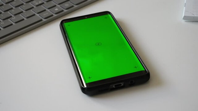 Smartphone with green screen chromakey on desk.