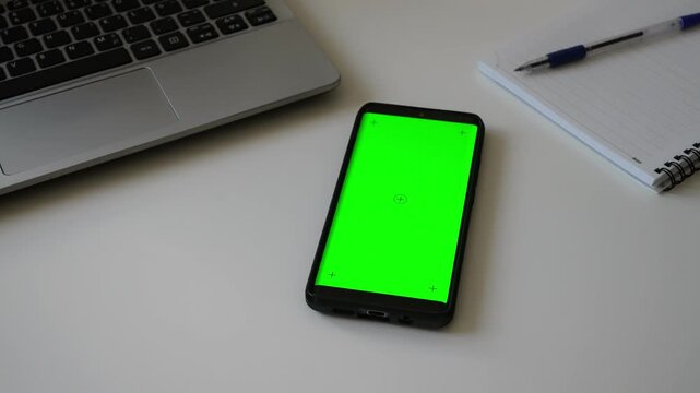 Smartphone with green screen chromakey on desk.