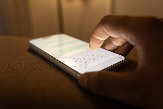 Man hands chatting and typing on smartphone macro closeup.