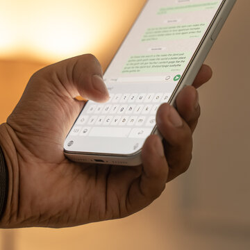 Man hands chatting and typing on smartphone macro closeup.