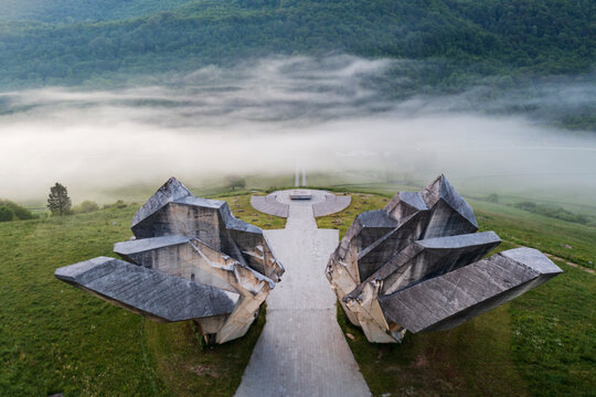 Tjenti&scaron;te War Memorial in Morning Fog, an elevated view of two dynamic and angled blocks of stone deep in the forest