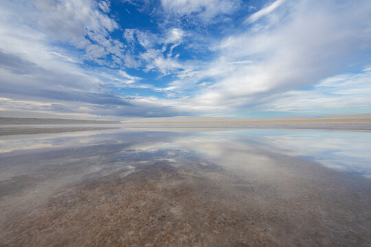 White Sands National Park, view across the flat landscape of the inland sands of the national park, a gypsum dunefield, with shallow surface water.