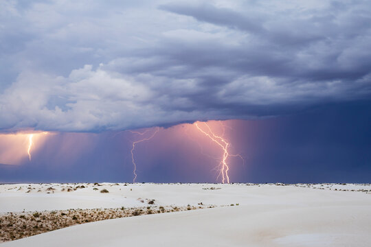 Lightning Strikes in White Sands National Park, forked lightning bolts reaching the ground.