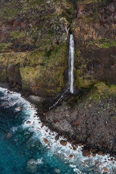 View of Corredo da Furna Waterfall tumbling down the cliff face at Porto Moniz in Madeira.