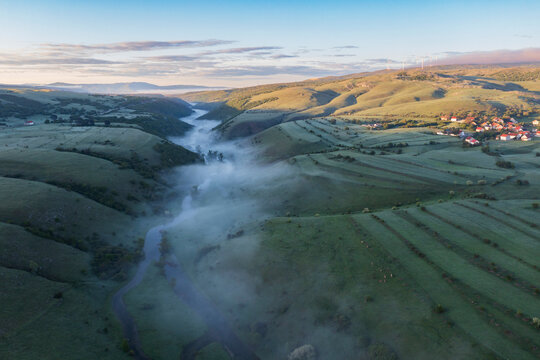 The meandering Suica River in the Duvanjsko Polje, the Duvno field valley, aerial view with mist hanging over the river.