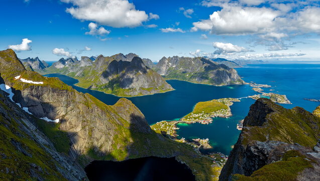 Reine, Norway - 13.07.2020: Majestic Lofoten mountains and deep blue fjords overlooking coastal villages under bright summer clouds