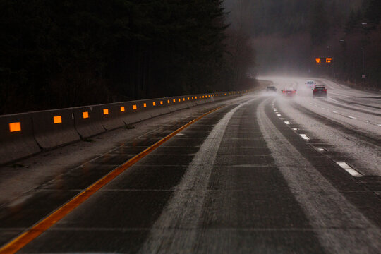 Driving over Snoqualmie Pass through the Cascade Mountains on Interstate 90 in winter, dark wet driving conditions.