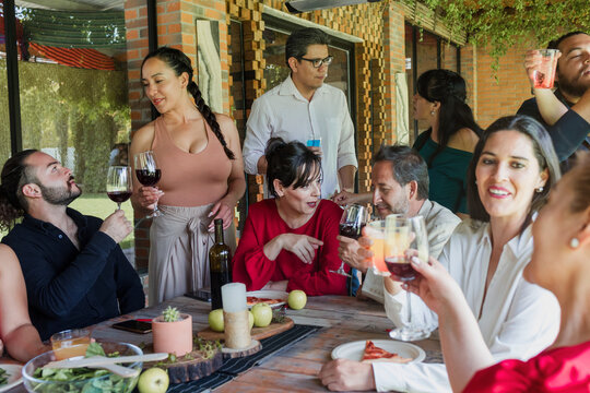 large group of latinos friends or multi generation family eating pizza and having a dinner in a terrace party in Mexico Latin America, hispanic diverse, multi age and multicultural people