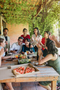 large group of latinos friends or multi generation family eating pizza and having a dinner in a terrace party in Mexico Latin America, hispanic diverse, multi age and multicultural people