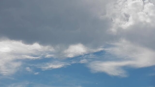 Different types of clouds with Mammatus clouds, Mammatocumulus and patch of blue sky in changeable summer weather - natural meteorological background, time lapse. Topics: meteorology, airspace, heaven