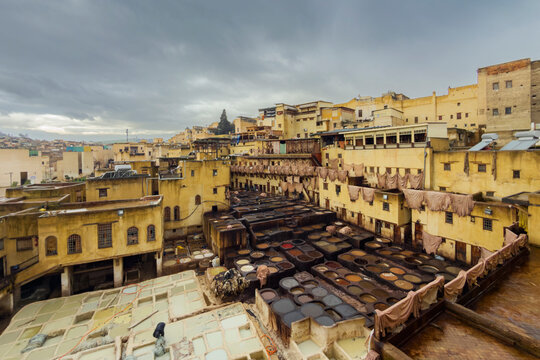 Chouara Tannery in Pouring Rain, elevated view over the dyeing pits of the tannery in the medina, a courtyard full of pits for dyeing animal hides.
