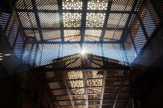 A latticework pattern on the roof of the souk, shadows and sunlight, sunbeams.