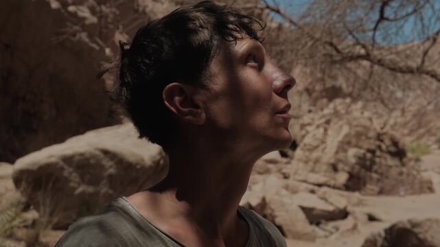 Young man with sweaty face standing in desert canyon under extreme heat illustrating heat stress dehydration climate change outdoor survival physical exhaustion and resilience