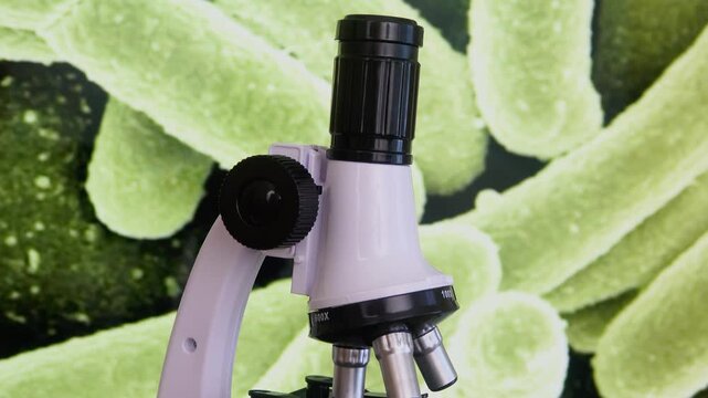 A laboratory microscope stands before a magnified E coli bacteria background, symbolizing microbiology research