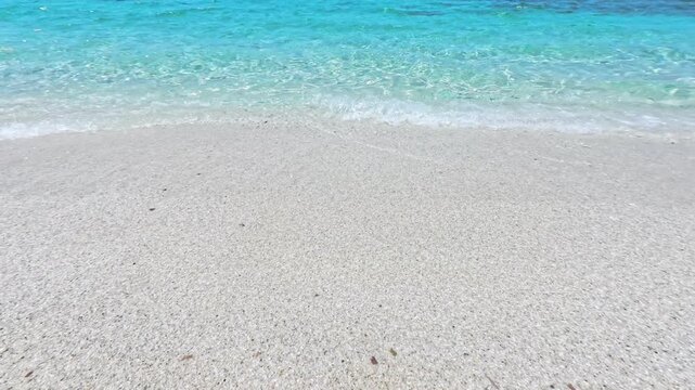 Colorful quartz pebbles and clear water on the shoreline at Mari Ermi, Sardinia, Italy
