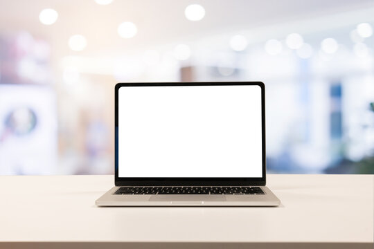 close up isolated on blank white screen display of laptop computer on table inside office room for add content of design banner , website or template or online shopping e-commerce concept