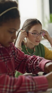 Vertical video of African American child and Caucasian classmate building robot in STEM class. Clip is perfect for marketing modern school curricula and science programs