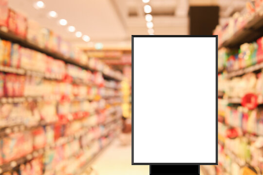 modern blank mockup poster (for ads commercial) standing over blur inside of megastore of local supermarket background in the weekend for billboard design and shopping grocery business concept
