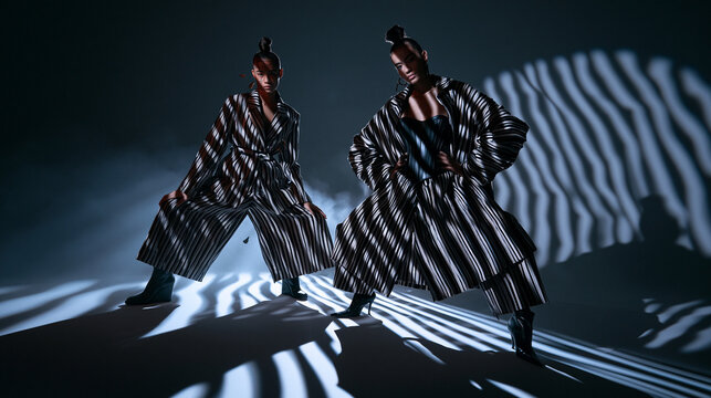 Fashion Models in Pinstriped Blazers with Dramatic Lighting