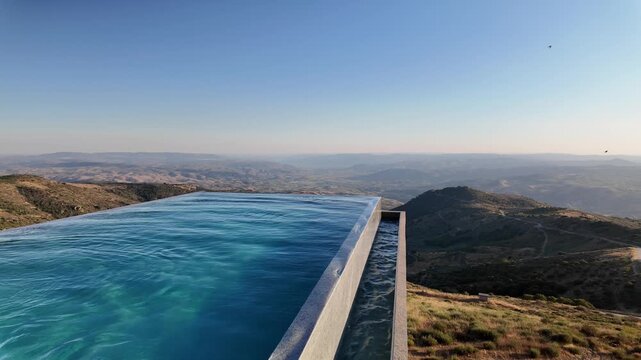 Luxury infinity pool overlooking mountain valley landscape