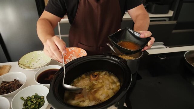 Chef skimming the fat off the bone broth from a slow cooker into a bowl