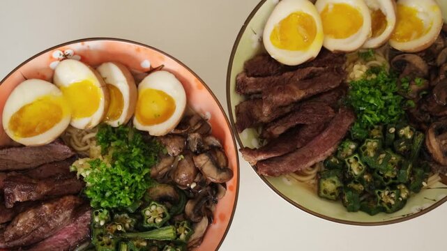 Delicious homemade ramen noodle soup with steak, soft boiled eggs, mushrooms and okra