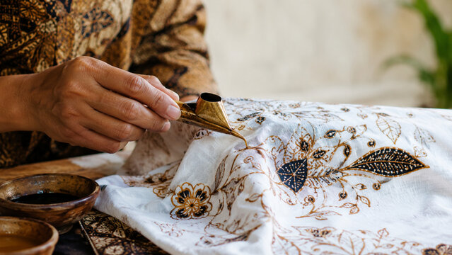 Indonesian Batik Artisan Hands Applying Traditional Wax Pattern on Fabric
