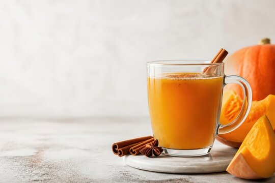 Pumpkin drink in glass mug with cinnamon stick