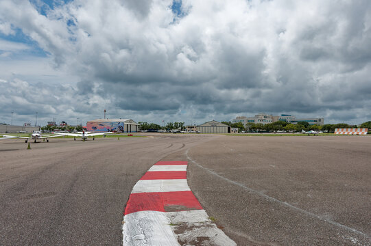 Small single-engine planes parked on wet tarmac at a regional Albert Whitted airport, hangars. Editorial Use Only July 29, 2026 St. Petersburg,FL USA. colorful mural visible in the background under dr