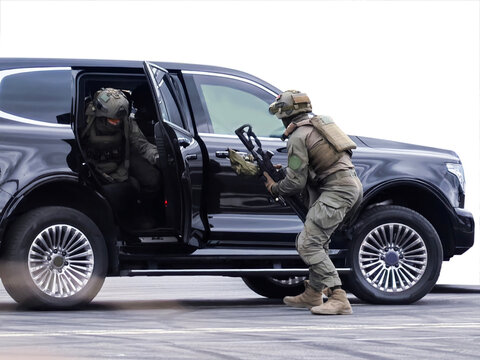 Tactical special forces operators exiting a black SUV during an operation for a security and defense concept