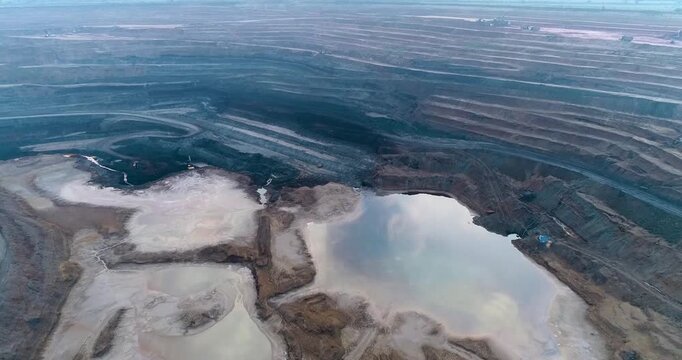 Aerial Drone View of Terraced Open Pit Coal Mine with Heavy Machinery in India
