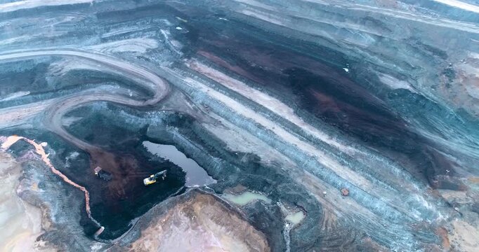 Aerial Drone View of Terraced Open Pit Coal Mine with Heavy Machinery in India
