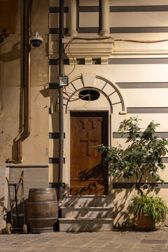 Monterosso door on the Italian coast in Cinque Terre with wooden cross and potted plants at night