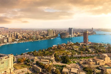 High angle view of Cairo city center and the Nile River under a dramatic orange sunset sky © AlexAnton
