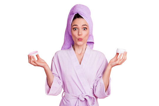 Portrait of attractive amazed stunned girl wearing turban on head holding in hands night cream pout lips isolated on pink pastel color background
