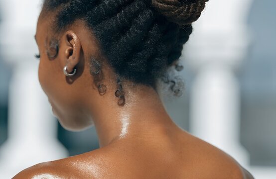 Glowing Skin: A Close-Up Of Curly Hair And Radiant Skin