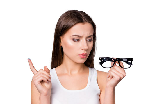 Close-up portrait of her she nice attractive lovely pretty doubtful discontent brown-haired girl holding in hands choosing specs lens medical prescription isolated over grey pastel color background