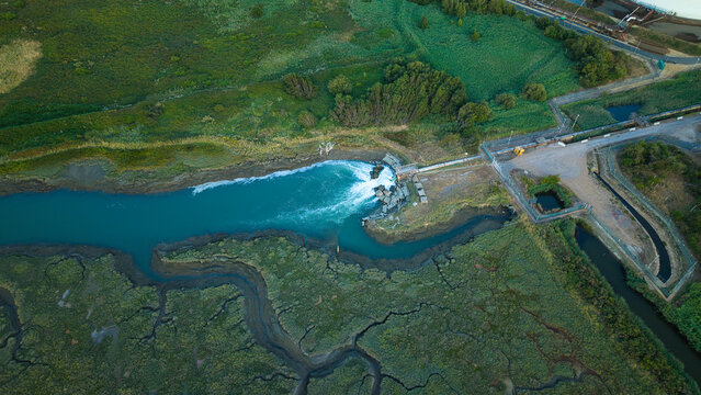Aerial view of the Fawley Refinery outfall discharging water into the surrounding wetland, featuring industrial infrastructure and marshland in Southampton, England, United Kingdom.