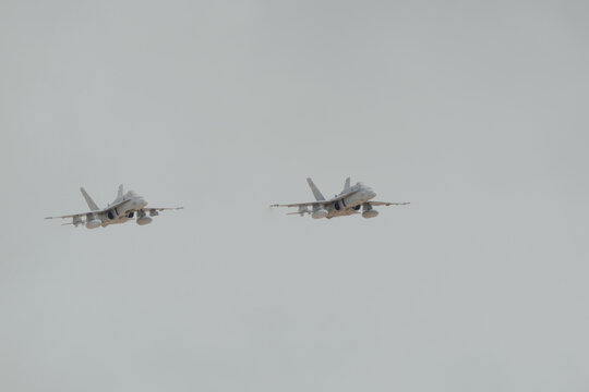 Albacete, Spain - June 12, 2026: Two F 18 fighter jet aircraft flying in formation over Los Llanos Air Base against a clear grey sky