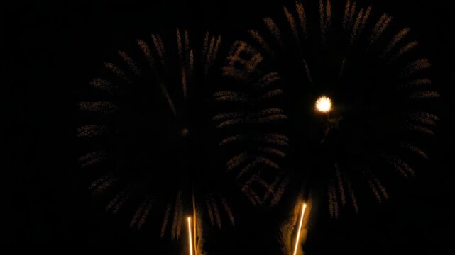 Golden fireworks display in the night sky, vibrant pyrotechnic show with bright light trails for festive celebrations and holiday events footage