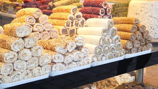 Close up footage of various turkish delight rolls stacked in display at sweet shop