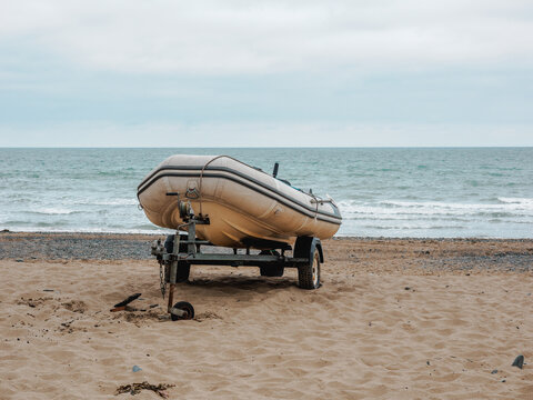 rubber dinghy boat craft on its trailer on the shoreline just having come out of the ocean