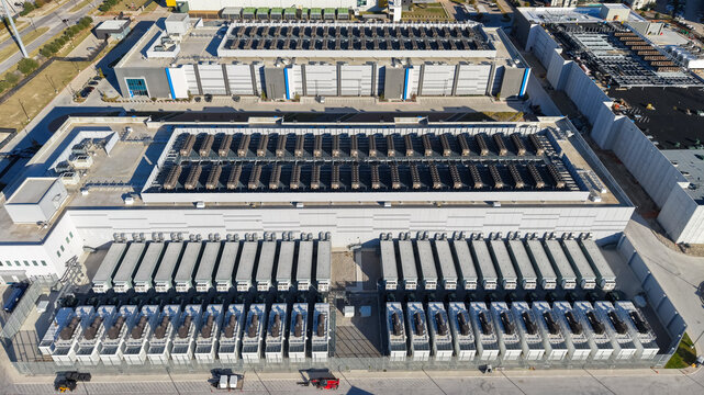 Aerial view of a large data center facility featuring extensive rooftop cooling units and industrial infrastructure in Richardson, Texas, United States.