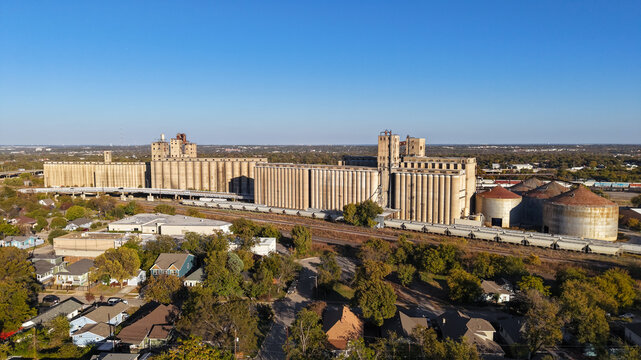 Aerial view of the historic grain elevators and industrial silos surrounded by railway tracks and residential houses in Fort Worth, Texas, United States.