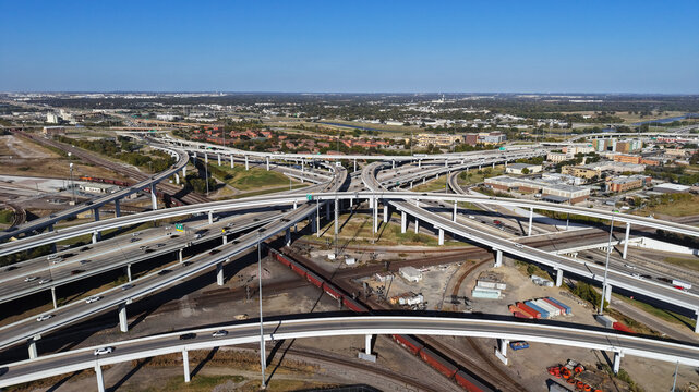 Aerial view of a complex highway interchange with multiple overpasses, lanes of traffic, and surrounding industrial areas in Fort Worth, Texas, United States.