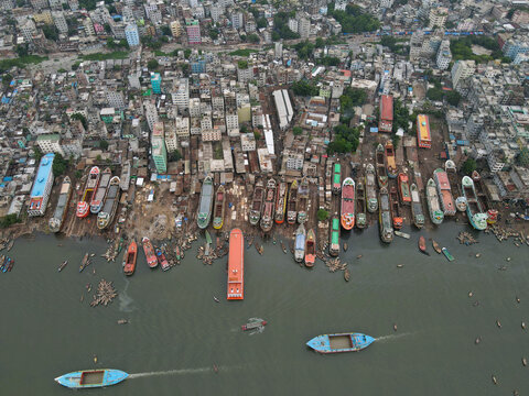 Aerial view of Sadarghat Launch Terminal with numerous passenger launches and cargo vessels docked along the Buriganga River in the dense urban landscape of Dhaka, Dhaka Division, Bangladesh.